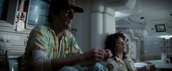 Movie still from “Alien” (1979), directed by Ridley Scott – A man sitting next to a woman smoking a cigarette; Medium shot, Low angle