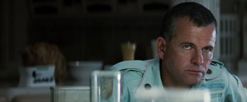 Movie still from “Alien” (1979), directed by Ridley Scott – A person sitting at a table; Close Up shot, Over the shoulder angle