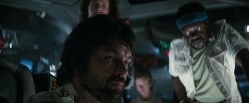 Movie still from “Alien” (1979), directed by Ridley Scott – A group of people standing around a man in a car; Close Up shot, Low angle