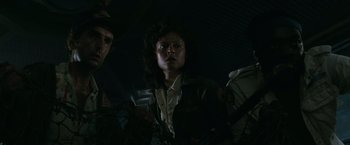 Movie still from “Alien” (1979), directed by Ridley Scott – A woman in a dark room looking at the camera; Close Up shot, Low angle