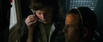 Movie still from “Alien” (1979), directed by Ridley Scott – A man and a woman looking at each other while on a cell phone; Close Up shot, Low angle