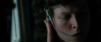 Movie still from “Alien” (1979), directed by Ridley Scott – A person with a headset on is looking at the camera; Close Up shot, Overhead angle