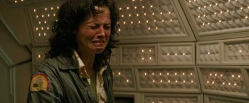 Movie still from “Alien” (1979), directed by Ridley Scott – A woman is crying in front of an array of lights; Close Up shot, Low angle