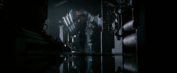 Movie still from “Alien” (1979), directed by Ridley Scott – A man standing inside of a room with a lot of lights; Wide shot, Low angle