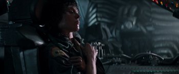 Movie still from “Alien” (1979), directed by Ridley Scott – A man in a green shirt is holding his hands up; Medium shot, Low angle