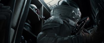 Movie still from “Alien” (1979), directed by Ridley Scott – A person in a spacesuit is standing in a room; Medium shot, Low angle