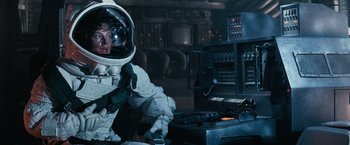 Movie still from “Alien” (1979), directed by Ridley Scott – A man in a spacesuit sitting in front of a computer; Medium shot, Over the shoulder angle