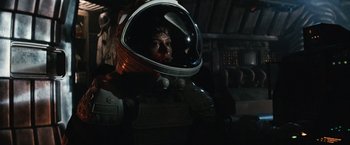 Movie still from “Alien” (1979), directed by Ridley Scott – A person in a space suit in a dark room; Medium shot, Low angle