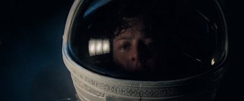 A person in a space helmet looking at the camera