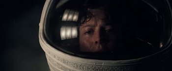 A man in a space helmet looking at the camera