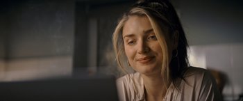 Movie still from “Flora and Son” (2023), directed by John Carney – A beautiful blonde woman sitting in front of a computer; Close Up shot, Low angle