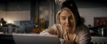 Movie still from “Flora and Son” (2023), directed by John Carney – A beautiful young lady sitting in front of an open laptop computer; Close Up shot, Over the shoulder angle