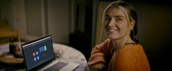 Movie still from “Flora and Son” (2023), directed by John Carney – A woman sitting in front of a laptop computer; Close Up shot, Over the shoulder angle