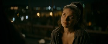 Movie still from “Flora and Son” (2023), directed by John Carney – A young woman is standing in front of a window at night; Close Up shot, Over the shoulder angle