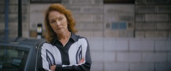 Movie still from “Flora and Son” (2023), directed by John Carney – An older woman wearing a black and white shirt; Medium shot, Low angle