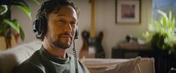 Movie still from “Flora and Son” (2023), directed by John Carney – A person sitting with a phone; Close Up shot, Low angle