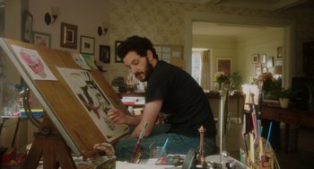 Movie still from “Flora & Ulysses” (2021), directed by Lena Khan – A man sitting in front of an easel painting a picture; Medium shot, Low angle
