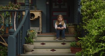 Movie still from “Flora & Ulysses” (2021), directed by Lena Khan – A little girl sitting on the steps of a house; Wide shot, Low angle