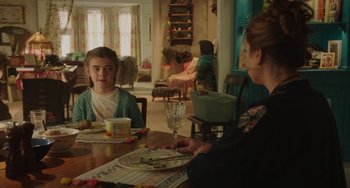 Movie still from “Flora & Ulysses” (2021), directed by Lena Khan – Two people sitting at a dining room table with food; Medium shot, Over the shoulder angle