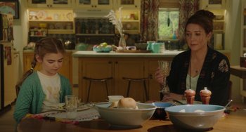 Movie still from “Flora & Ulysses” (2021), directed by Lena Khan – Two people sitting at a table with a bowl of fruit; Medium shot, Over the shoulder angle