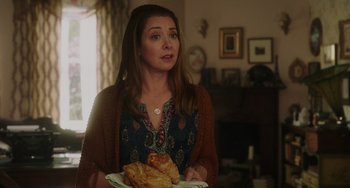 Movie still from “Flora & Ulysses” (2021), directed by Lena Khan – A woman holding a plate of food in a living room; Close Up shot, Over the shoulder angle