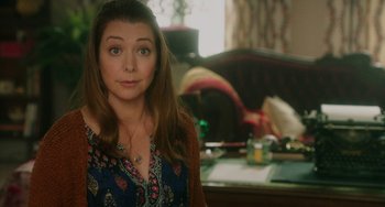 Movie still from “Flora & Ulysses” (2021), directed by Lena Khan – A woman standing in front of a desk with a laptop; Close Up shot, Over the shoulder angle