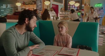 Movie still from “Flora & Ulysses” (2021), directed by Lena Khan – A man and a little girl sitting at a table in a restaurant; Medium shot, Over the shoulder angle