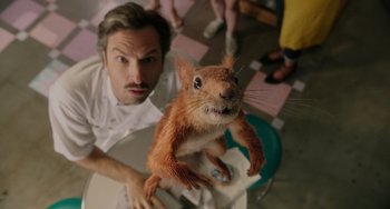Movie still from “Flora & Ulysses” (2021), directed by Lena Khan – A man and a red squirrel on the floor; Extreme Close Up shot, Over the shoulder angle