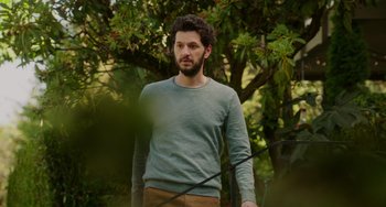 Movie still from “Flora & Ulysses” (2021), directed by Lena Khan – A man standing in front of a tree; Medium shot, Low angle