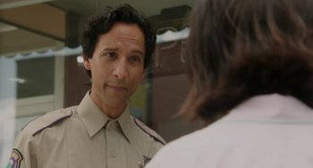 Movie still from “Flora & Ulysses” (2021), directed by Lena Khan – A man in a police uniform looking at himself in the mirror; Close Up shot, Over the shoulder angle