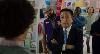 Movie still from “Flora & Ulysses” (2021), directed by Lena Khan – A group of people standing around in a store; Medium shot, Over the shoulder angle