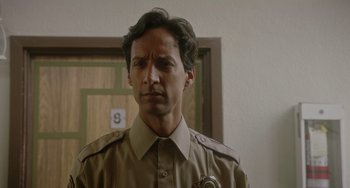 Movie still from “Flora & Ulysses” (2021), directed by Lena Khan – A man in a uniform is standing in front of a door; Close Up shot, Over the shoulder angle