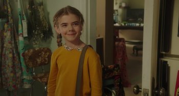Movie still from “Flora & Ulysses” (2021), directed by Lena Khan – A young girl in a yellow sweater with braids; Close Up shot, Over the shoulder angle