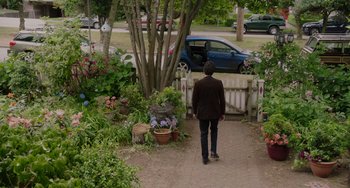 Movie still from “Flora & Ulysses” (2021), directed by Lena Khan – A person walking down a path in a garden; Wide shot, High angle