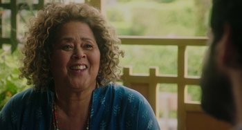 Movie still from “Flora & Ulysses” (2021), directed by Lena Khan – An older woman with curly blonde hair smiling; Close Up shot, Over the shoulder angle