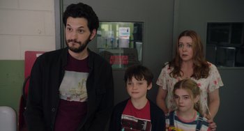 Movie still from “Flora & Ulysses” (2021), directed by Lena Khan – A man and three children standing in front of a elevator; Medium shot, Over the shoulder angle