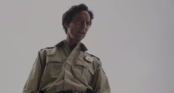 Movie still from “Flora & Ulysses” (2021), directed by Lena Khan – A man in a uniform is standing in front of the sky; Close Up shot, Low angle