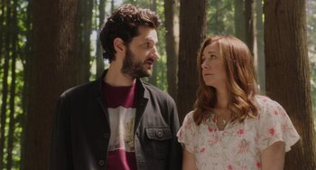 Movie still from “Flora & Ulysses” (2021), directed by Lena Khan – A man and a woman standing next to each other in the woods; Medium shot, Over the shoulder angle