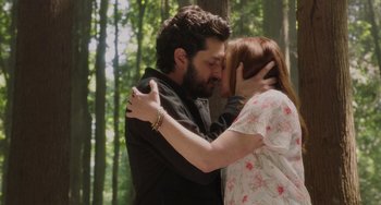 Movie still from “Flora & Ulysses” (2021), directed by Lena Khan – A man and a woman kissing in the woods; Medium shot, High angle