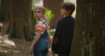 Movie still from “Flora & Ulysses” (2021), directed by Lena Khan – A girl and a boy standing next to a tree; Medium shot, High angle