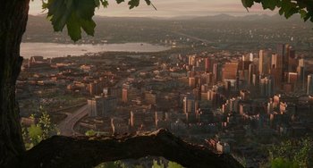 Movie still from “Flora & Ulysses” (2021), directed by Lena Khan – An aerial view of a large city with a lake in the background; Extreme Wide shot, High angle