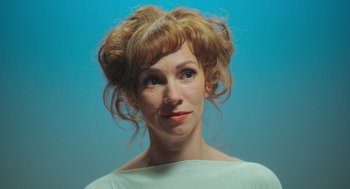 Movie still from “Flux Gourmet” (2022), directed by Peter Strickland – A person wearing a white shirt; Close Up shot, Low angle