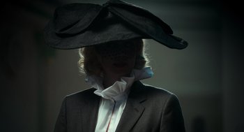 Movie still from “Flux Gourmet” (2022), directed by Peter Strickland – A woman in a suit and a black hat; Close Up shot, Low angle