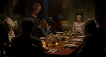 Movie still from “Flux Gourmet” (2022), directed by Peter Strickland – A group of people sitting at a table with food; Medium shot, Over the shoulder angle