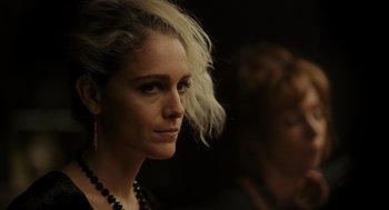 Movie still from “Flux Gourmet” (2022), directed by Peter Strickland – A person wearing a necklace; Close Up shot, Low angle