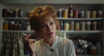 Movie still from “Flux Gourmet” (2022), directed by Peter Strickland – A woman smoking a cigarette while wearing a white shirt; Close Up shot, Low angle