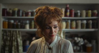 Movie still from “Flux Gourmet” (2022), directed by Peter Strickland – A person wearing a white shirt; Close Up shot, Over the shoulder angle