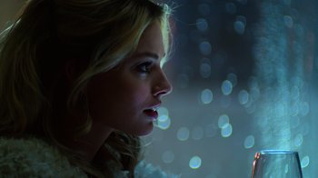 Movie still from “Focus” (2015), directed by John Requa – A beautiful blonde woman looking out a window; Close Up shot, Low angle