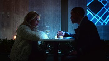 Movie still from “Focus” (2015), directed by John Requa – A man and a woman sitting at a table with a glass of wine in front of them; Medium shot, Over the shoulder angle