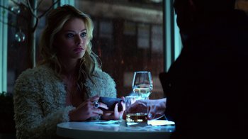 Movie still from “Focus” (2015), directed by John Requa – A woman sitting at a table with a glass of wine; Close Up shot, Over the shoulder angle